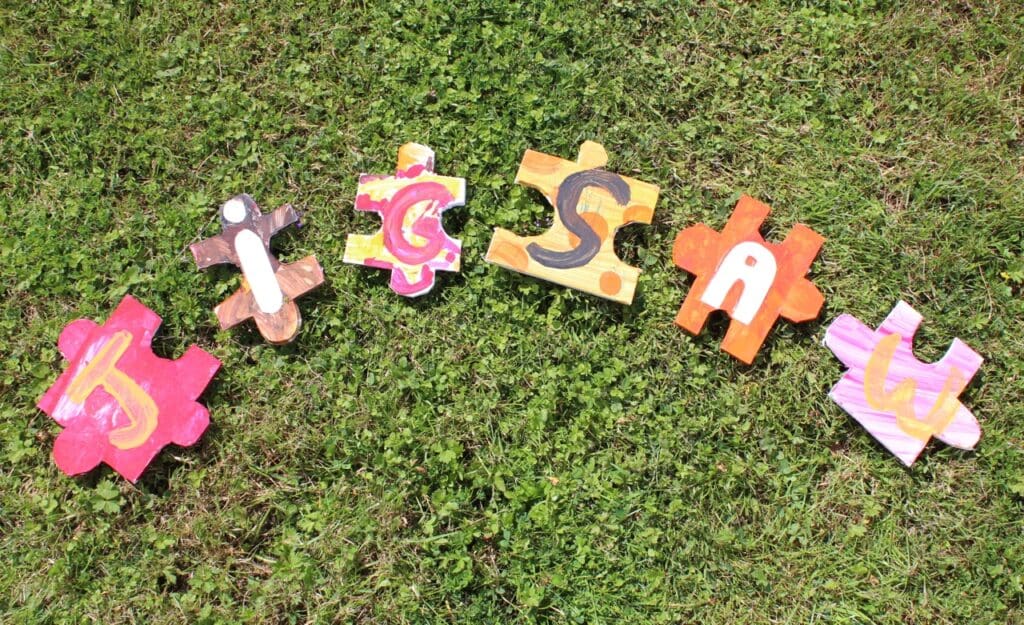 Jigsaw cutout letters wood on grass